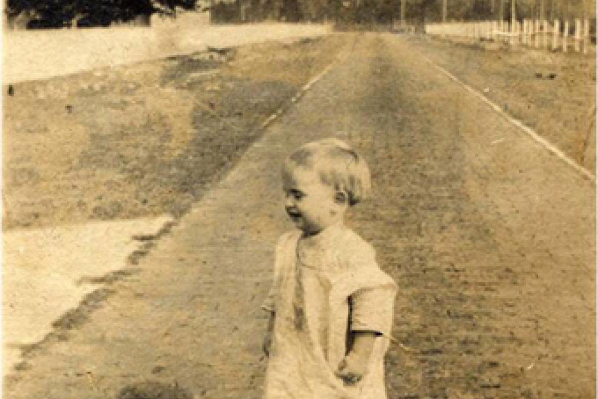 old photo of a child standing on the old brick road 